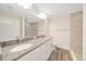 Bathroom featuring a double sink vanity with granite countertop and tiled shower at 10675 Sw 69Th Ter, Ocala, FL 34476