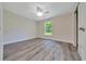 Bedroom features modern ceiling fan, window and stylish gray plank flooring at 10675 Sw 69Th Ter, Ocala, FL 34476