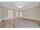 Bright bedroom with tray ceiling, ceiling fan, luxury vinyl plank flooring, and ensuite bathroom at 10675 Sw 69Th Ter, Ocala, FL 34476