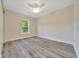 Bedroom features modern ceiling fan, window and stylish gray plank flooring at 10675 Sw 69Th Ter, Ocala, FL 34476
