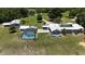 Aerial view of the property with a pool, detached garage and well-manicured landscaping at 10893 Se 141 Avenue Rd, Ocklawaha, FL 32179