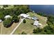 Aerial view showcases the home's layout, screened pool, and proximity to the lake at 10893 Se 141 Avenue Rd, Ocklawaha, FL 32179