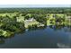 Scenic aerial of lakefront property, featuring pool, dock, and mature trees at 10893 Se 141 Avenue Rd, Ocklawaha, FL 32179