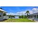 Expansive backyard with a view of the lake and a screened-in pool, complete with palm trees and lush green grass at 10893 Se 141 Avenue Rd, Ocklawaha, FL 32179
