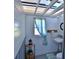A compact bathroom with a sink, toilet, window with curtain, and cabinet storage below at 10893 Se 141 Avenue Rd, Ocklawaha, FL 32179