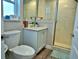 Cozy bathroom featuring a toilet, vanity with marble countertop, and a walk-in shower with glass doors at 10893 Se 141 Avenue Rd, Ocklawaha, FL 32179