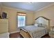 Cozy bedroom features a comfy bed, window with blinds, and classic decor at 10893 Se 141 Avenue Rd, Ocklawaha, FL 32179