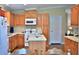 Well-lit kitchen with wooden cabinets, center island, and modern appliances at 10893 Se 141 Avenue Rd, Ocklawaha, FL 32179
