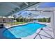 A beautiful screened-in pool with a white frame and a serene waterfront view from the backyard at 10893 Se 141 Avenue Rd, Ocklawaha, FL 32179