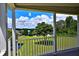 Picturesque porch view overlooking a lush lawn, lake, and blue skies at 10893 Se 141 Avenue Rd, Ocklawaha, FL 32179