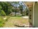 Expansive backyard with mature trees, a lush lawn, and a rear view of the home's exterior at 11645 Mallard Ct, Dunnellon, FL 34432