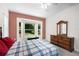 Bright bedroom features large window, neutral walls, ceiling fan and complemented by classic wood dresser at 11645 Mallard Ct, Dunnellon, FL 34432