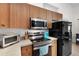 Kitchen showcasing stainless steel appliances, wood cabinets and tiled floor at 11645 Mallard Ct, Dunnellon, FL 34432