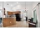 Open-concept kitchen featuring wood cabinetry, a breakfast bar, and tile flooring, next to a patio sitting area at 11645 Mallard Ct, Dunnellon, FL 34432