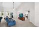 Bright living room featuring a vaulted ceiling, a comfortable blue sofa, and a large television at 11645 Mallard Ct, Dunnellon, FL 34432