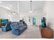 Spacious living room with vaulted ceilings, a blue reclining sofa, and sliding glass doors at 11645 Mallard Ct, Dunnellon, FL 34432