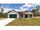Beautiful single story house with a green garage door and wood-accented porch at 12251 Sw 67Th Ln, Ocala, FL 34481