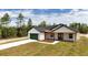 A modern farmhouse featuring white siding, a dark roof, green garage door, and a welcoming front porch at 12251 Sw 67Th Ln, Ocala, FL 34481