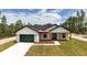 A stunning one-story house with a green garage door and wood porch accents at 12251 Sw 67Th Ln, Ocala, FL 34481