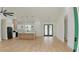 A spacious living room and kitchen area features modern lighting, light wood floors, and sleek black appliances at 12251 Sw 67Th Ln, Ocala, FL 34481