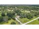 Picturesque aerial view of a countryside home featuring a long driveway and surrounded by lush, mature trees at 15620 Nw 112Th Ave, Reddick, FL 32686