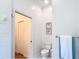 Toilet in renovated bathroom with white subway tile and view to closet with shelving at 15620 Nw 112Th Ave, Reddick, FL 32686