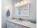 Bathroom vanity with white cabinetry, marble countertop, and decorative mirror and lighting at 15620 Nw 112Th Ave, Reddick, FL 32686