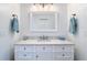 Bathroom vanity with white cabinetry, marble countertop, and decorative mirror and lighting at 15620 Nw 112Th Ave, Reddick, FL 32686