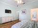 Bedroom featuring wooden floors, TV, ceiling fan and view to ensuite bathroom at 15620 Nw 112Th Ave, Reddick, FL 32686