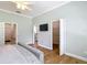 Bedroom features hardwood floors, ceiling fan, and entrances to the bathroom and walk-in closet at 15620 Nw 112Th Ave, Reddick, FL 32686