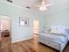 Bright bedroom with wooden floors, ceiling fan, and view to ensuite bathroom and sitting area at 15620 Nw 112Th Ave, Reddick, FL 32686