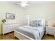 Bright bedroom boasts a ceiling fan, white dresser and nightstand, and hardwood flooring at 15620 Nw 112Th Ave, Reddick, FL 32686