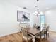 Bright dining room with chandelier, hardwood floors, and adjacent to open kitchen at 15620 Nw 112Th Ave, Reddick, FL 32686