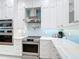 Modern kitchen with stainless steel oven, range hood, and sleek white countertops and cabinets at 15620 Nw 112Th Ave, Reddick, FL 32686