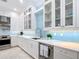 Bright kitchen with white cabinets, blue backsplash, stainless steel appliances, and a floral rug at 15620 Nw 112Th Ave, Reddick, FL 32686