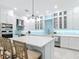 Kitchen island surrounded by stools, with a view of stainless steel appliances and white cabinets at 15620 Nw 112Th Ave, Reddick, FL 32686