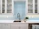 Close up on sink in kitchen with blue tile backsplash, white cabinetry, and stainless steel faucet at 15620 Nw 112Th Ave, Reddick, FL 32686