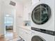 Bright laundry room with stacked laundry, sink, and doorway to bedroom at 15620 Nw 112Th Ave, Reddick, FL 32686