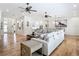 Living room with hardwood floors, large sectional sofa, ceiling fans, and open floor plan at 15620 Nw 112Th Ave, Reddick, FL 32686