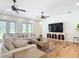 Open concept living room features hardwood floors, large sectional sofa, ceiling fans, and a TV at 15620 Nw 112Th Ave, Reddick, FL 32686
