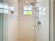 Modern shower with a rainfall showerhead, sleek glass enclosure, and tiled walls at 15620 Nw 112Th Ave, Reddick, FL 32686