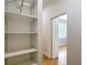Walk-in closet features white shelving and hardwood floors at 15620 Nw 112Th Ave, Reddick, FL 32686