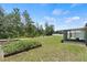 Backyard featuring mature trees, raised garden beds, and a screened-in porch at 15994 Sw 55Th Avenue Rd, Ocala, FL 34473