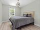 Bedroom featuring a bed with upholstered headboard, wood-look floors and natural light at 15994 Sw 55Th Avenue Rd, Ocala, FL 34473