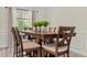 Well-lit dining area with a wooden table and six chairs in front of a window at 15994 Sw 55Th Avenue Rd, Ocala, FL 34473