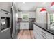 Modern kitchen with stainless steel appliances, granite countertops, and white cabinets at 15994 Sw 55Th Avenue Rd, Ocala, FL 34473