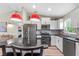 Modern kitchen featuring stainless steel appliances, white cabinetry, and red pendant lights at 15994 Sw 55Th Avenue Rd, Ocala, FL 34473