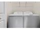 A functional laundry room with a standard washer and dryer set and wire shelving for storage at 15994 Sw 55Th Avenue Rd, Ocala, FL 34473