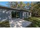 Concrete back patio featuring sliding glass doors, gray siding, and a view of the backyard at 16615 Se 63Rd Ln, Ocklawaha, FL 32179