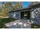 Concrete back patio featuring sliding glass doors, gray siding, and a view of the yard and trees at 16615 Se 63Rd Ln, Ocklawaha, FL 32179